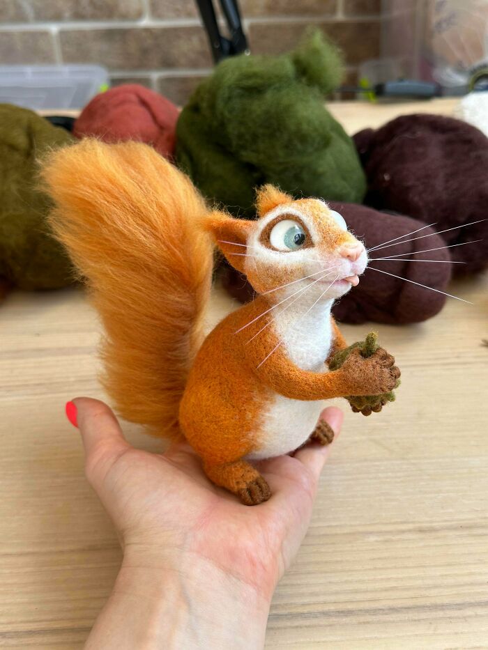 A felted squirrel holding an acorn, a charming example of handmade projects.