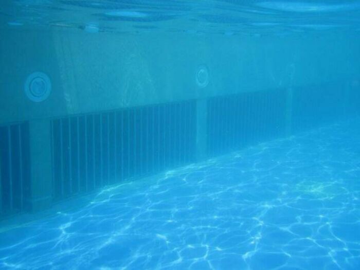 Uncomfortable water pics of a submerged pool wall with grates, creating a feeling of being small.