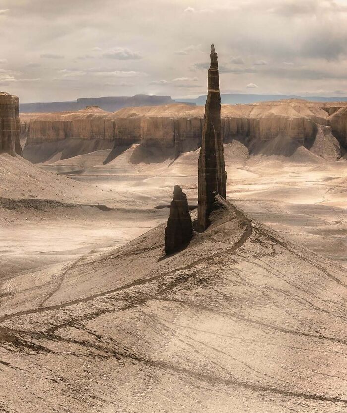 Unbelievable photos of a tall, thin rock formation in a desolate desert landscape on Earth, like another universe.