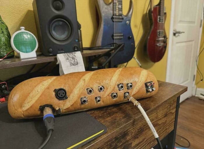 A DiWHY project: a baguette transformed into an audio mixer with cables connected, on a wooden desk.