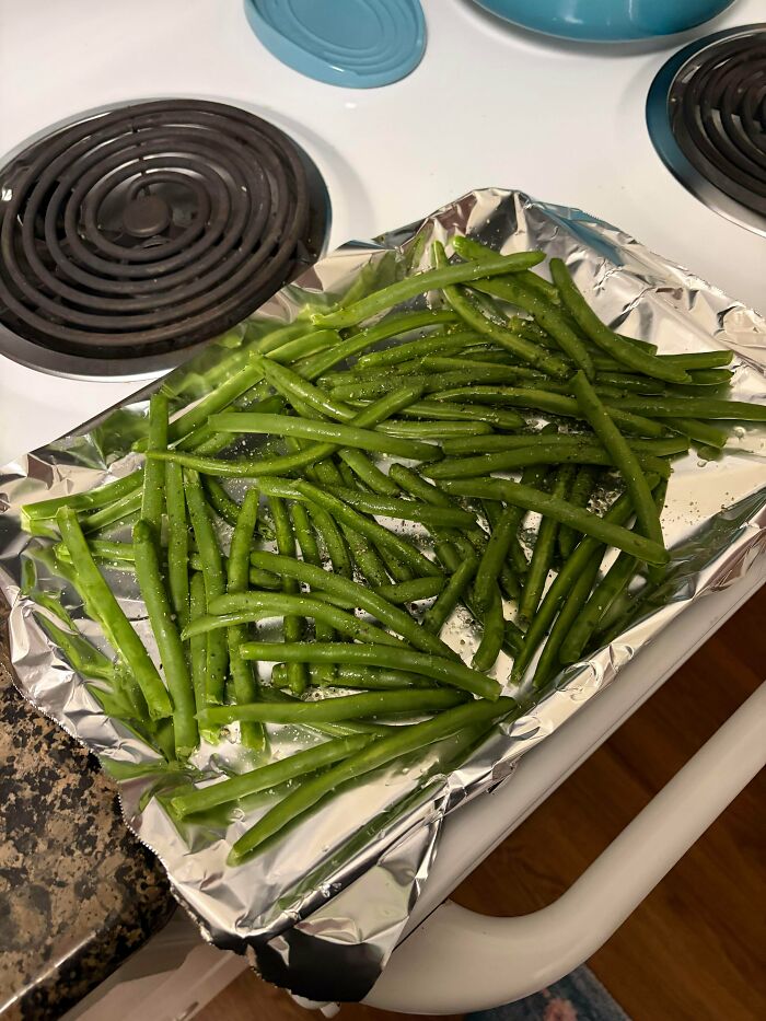 Green beans seasoned on a foil-lined baking sheet, part of a balanced Girl Dinner.