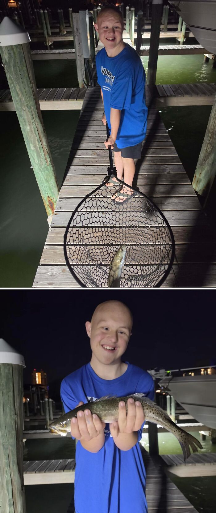 A happy boy on a dock at night, holding a fish he just caught in a net, a proud moment for dads.