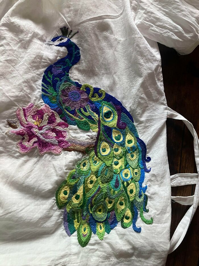 Stunning embroidery creation of a vibrant peacock with a pink flower, inspiring a new hobby.