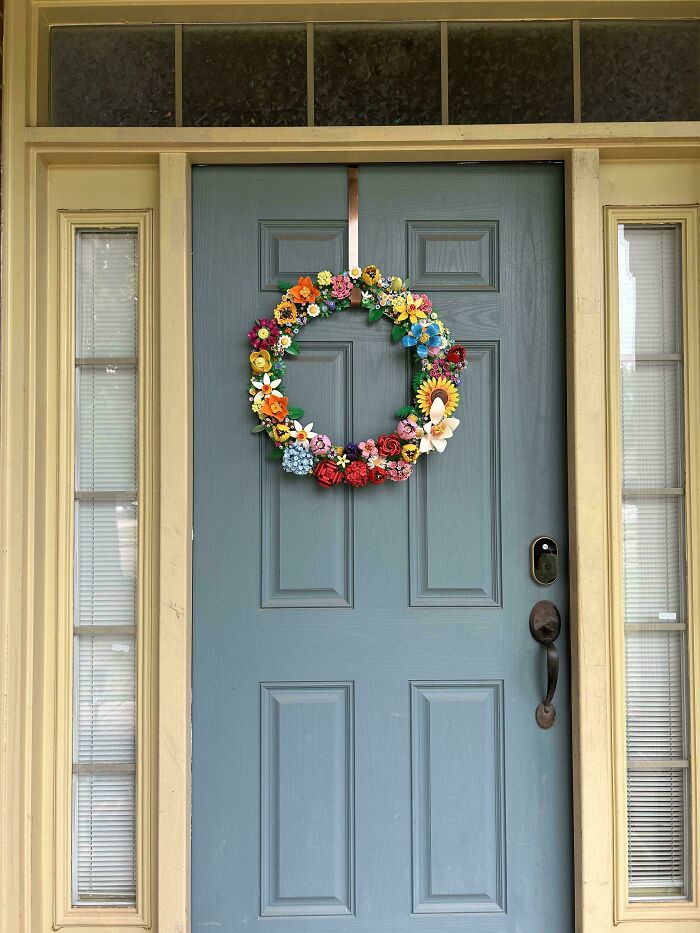 A vibrant handmade floral wreath on a blue door, a beautiful handmade project.