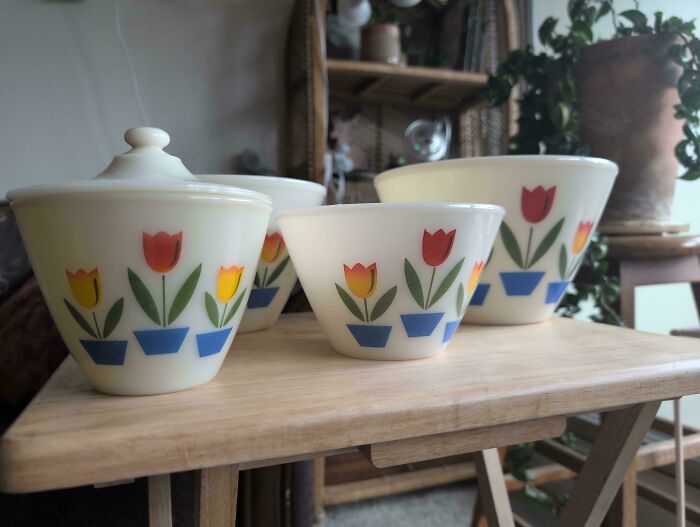 Set of vintage Pyrex bowls with colorful tulip patterns, a classic thrift store find.