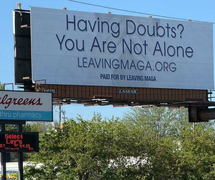 A billboard with the text Having Doubts? You Are Not Alone LEAVINGMAGA.ORG, a public message inspiring a chaotic good shift.