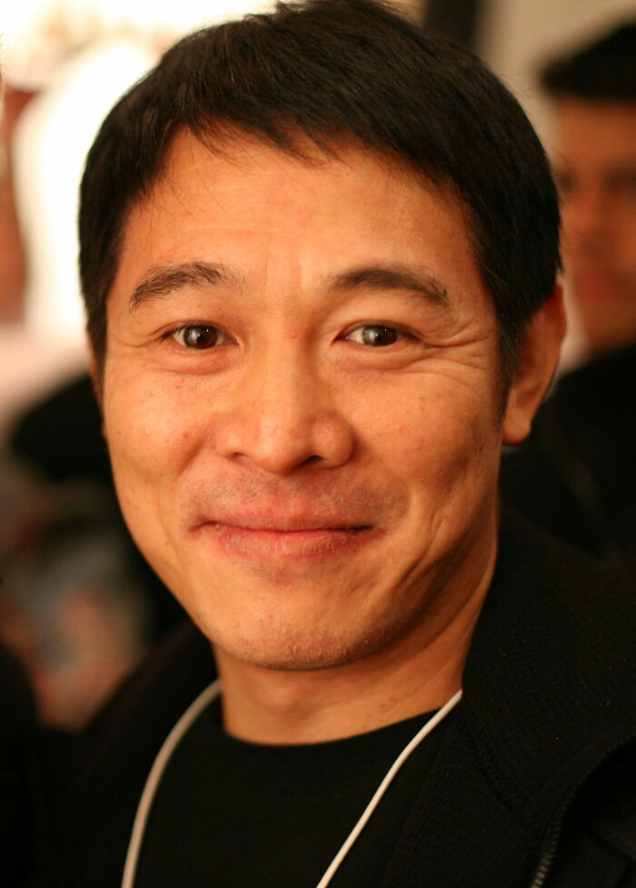 Jet Li, actor and martial artist, smiling in a close-up shot, showcasing his career highlights and bio.