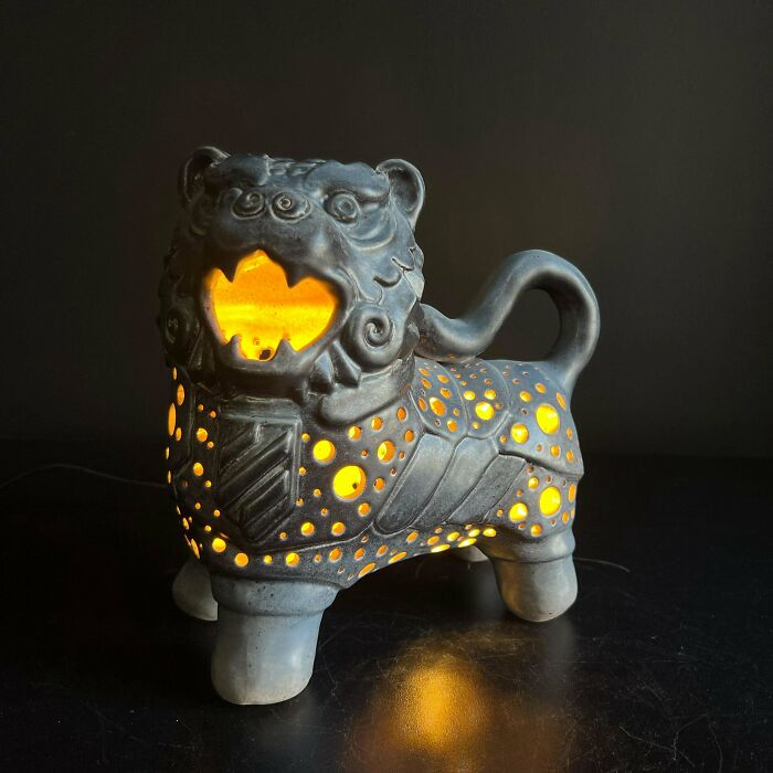A handmade foo dog lantern glowing with yellow light, showcasing talent and magic.