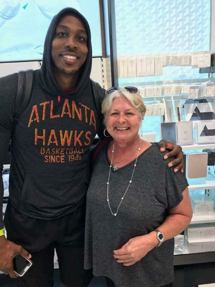 A tall man in an Atlanta Hawks hoodie smiles with a smiling older woman. Celebrity encounters can be memorable.