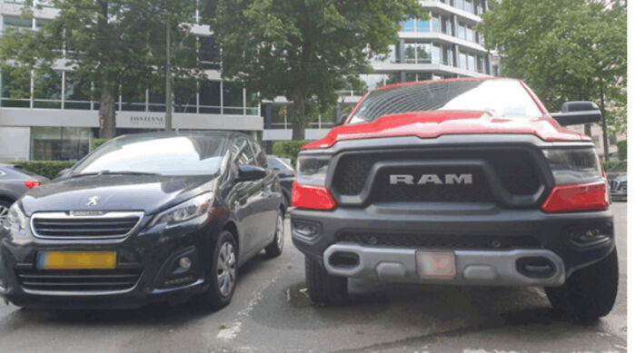 A small car next to a large truck, illustrating consumerism and a significant price difference.