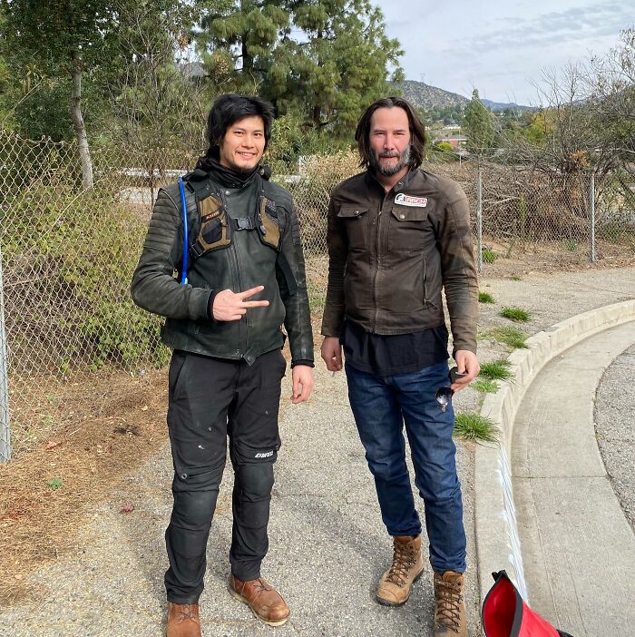 Keanu Reeves and a fan on a roadside. A casual celebrity encounter, showing the unexpected moments of meeting stars.