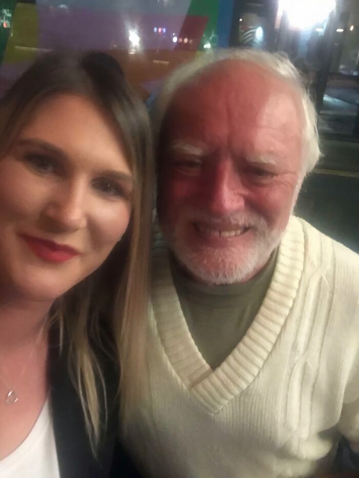 A woman smiling next to Hide the Pain Harold, an internet celebrity. A genuine celebrity encounter photo.