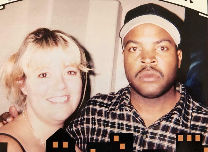 A woman with blonde hair smiling beside Ice Cube, who wears a plaid shirt and cap. A celebrity encounter photo.
