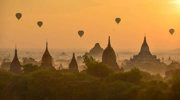 Hot air balloons float over ancient temples at sunrise, a satisfying picture for a gentle reset button for your day.