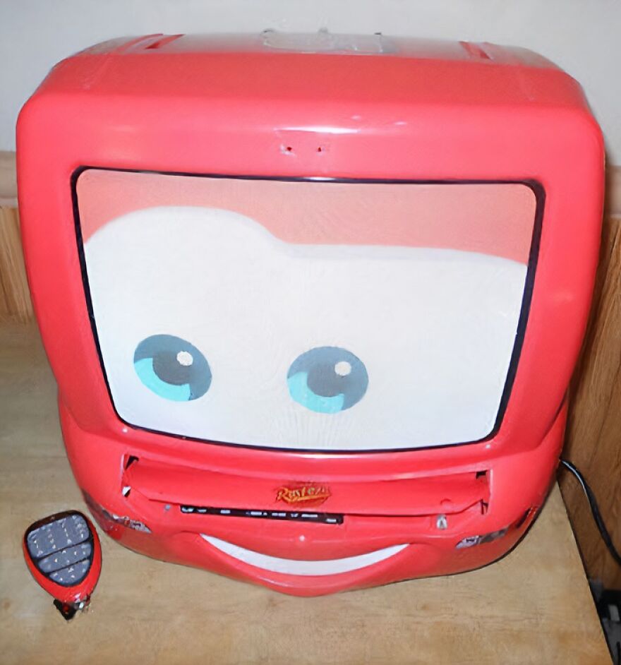 A red Lightning McQueen shaped TV and VCR combo with a remote, designed for kids. It makes people take a trip down memory lane.