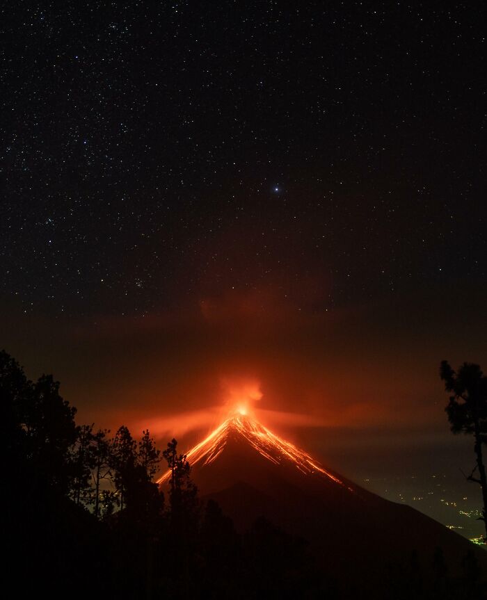 A mesmerizing night view of a glowing red erupting volcano under a starry sky, offering a gentle reset.