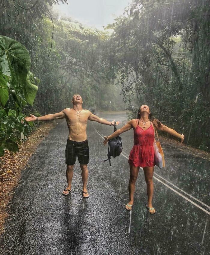 A couple stands in the rain with arms outstretched, looking up. A satisfying picture for a gentle reset.
