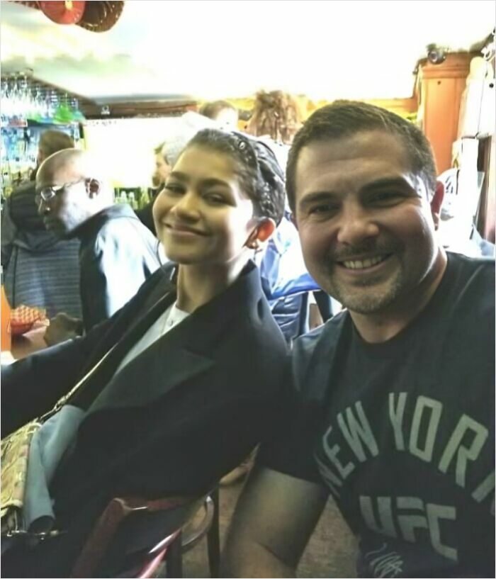 Zendaya smiling in a celebrity encounter photo with a fan in a New York UFC shirt. Wild photos of celebrity encounters.