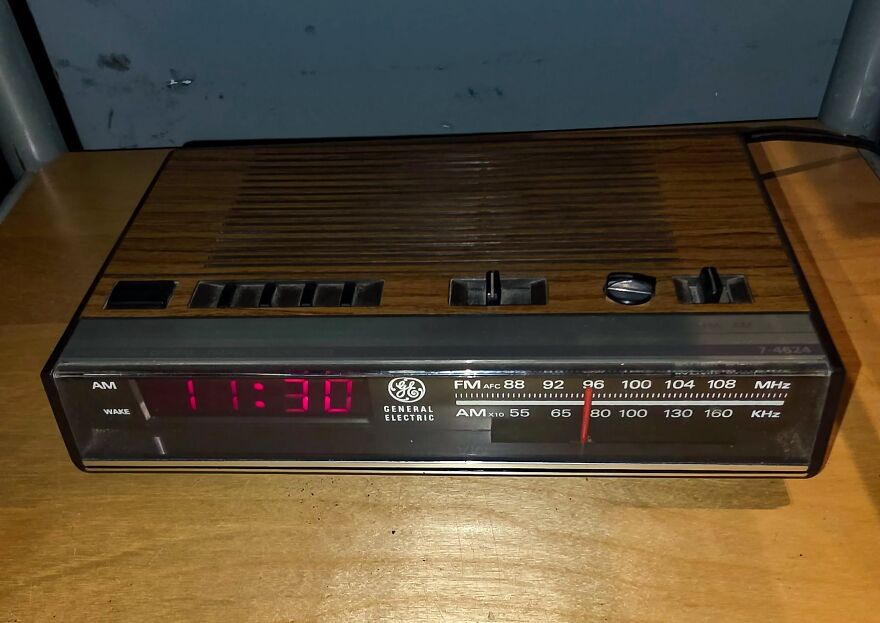 A vintage General Electric digital alarm clock radio with a wood grain top, showing 11:30 and the radio dial. Takes a trip down memory lane.