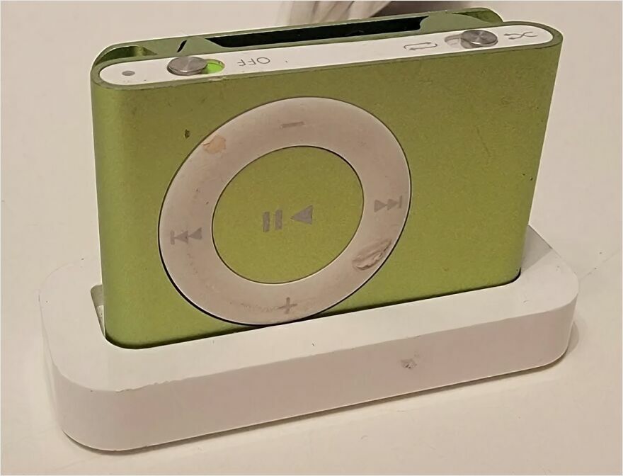 A nostalgic green iPod Nano in a white charging dock, stirring a trip down memory lane for many.