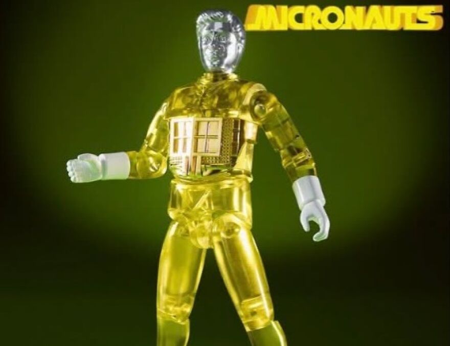 A vintage Micronauts action figure, translucent yellow with a metallic head, evoking nostalgia and a trip down memory lane.