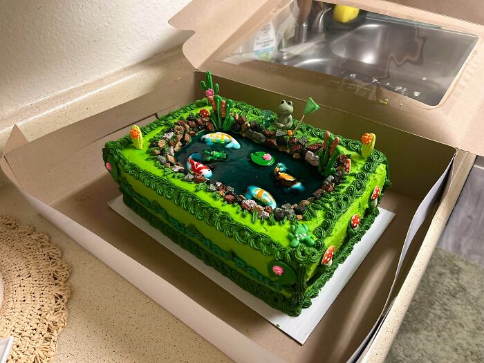 Rectangular green pond-themed cake with fish and frog decorations