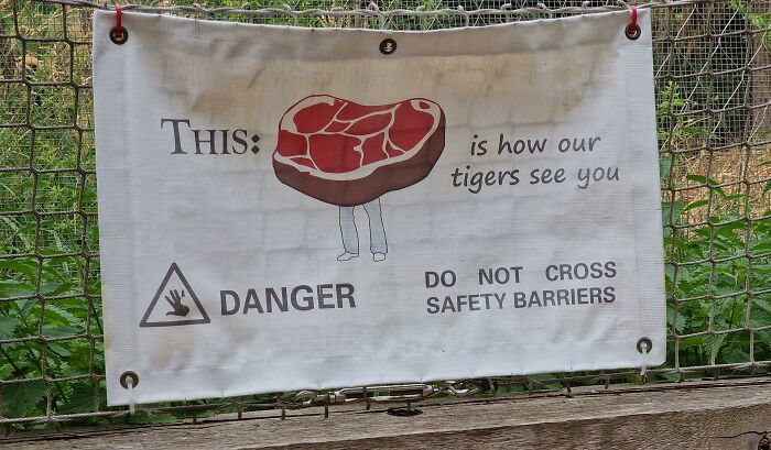Warning sign humorously showing how tigers see visitors as meat