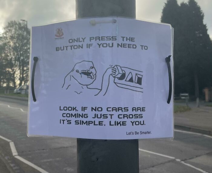 Humorous street sign advising only press button if cars are coming