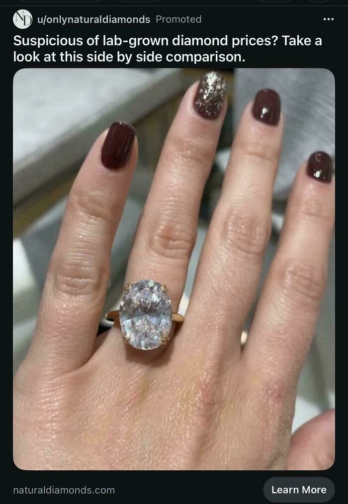Hand with a large diamond ring, illustrating the price difference and consumerism.