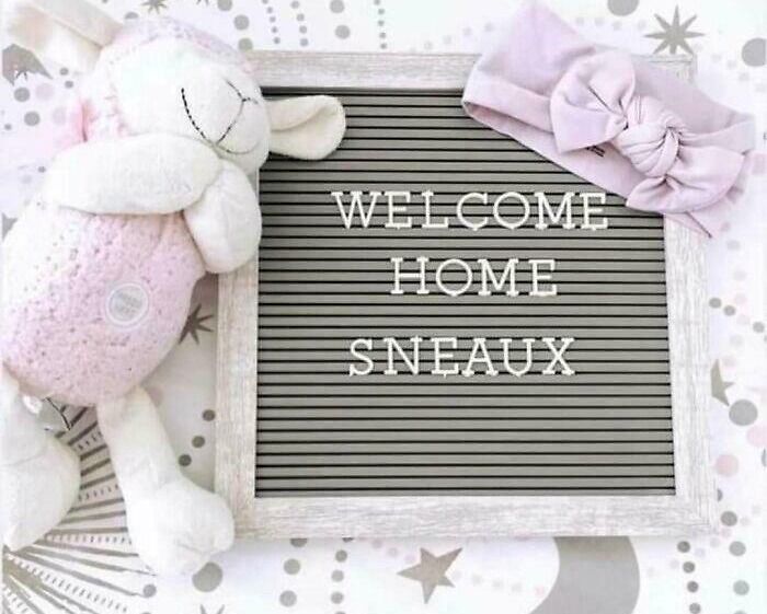 A letter board says WELCOME HOME SNEAUX, next to a lamb plush and baby headband. Parents naming kids.