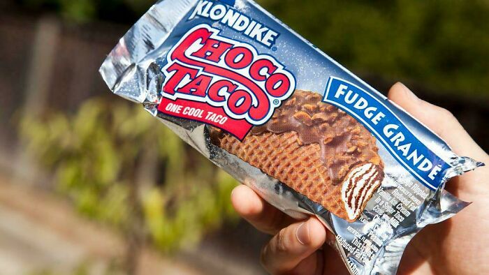 A hand holding a Klondike Choco Taco, creating a meme that only true '90s kids will understand.