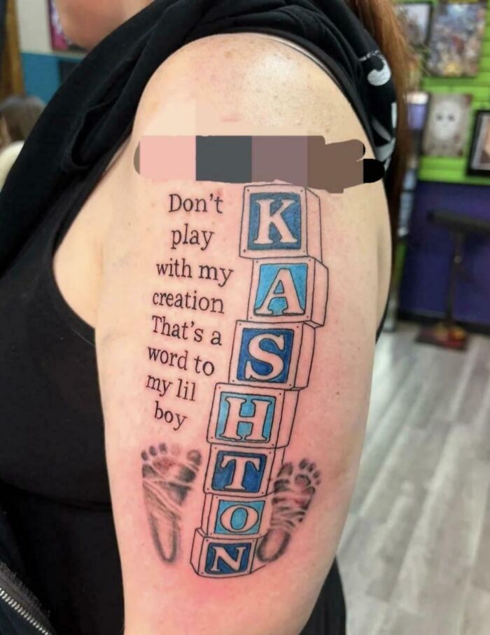 A tattoo on an arm showing baby blocks spelling KASHTON, infant footprints, and the text "Don't play with my creation That's a word to my lil boy." A parents naming their kids example.