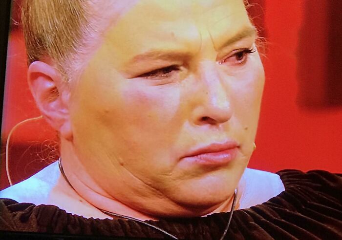 A woman looking distressed with tears in her eyes, likely from a beauty disaster at the salon.