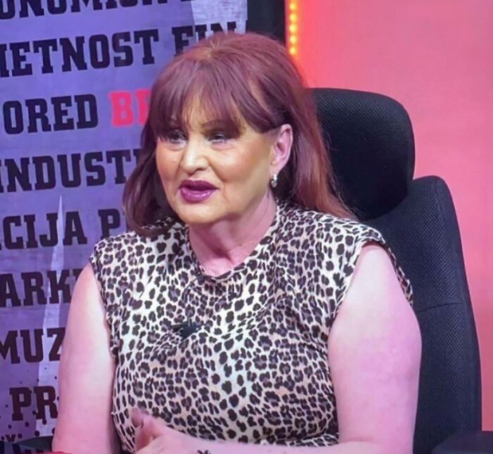 Woman with auburn hair in a leopard print top, possibly discussing beauty disasters, a common salon topic.