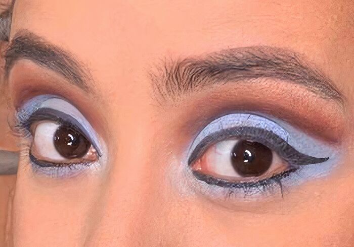 Close-up of eyes with blue eyeshadow and eyeliner, hinting at a beauty disaster.