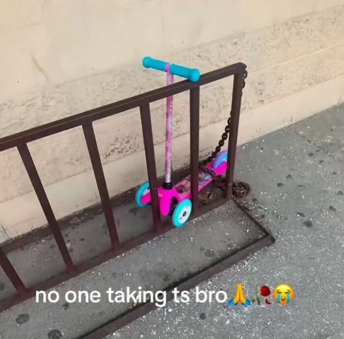 A small pink scooter chained to a bike rack, an unhinged pic that makes no sense but is hilarious.