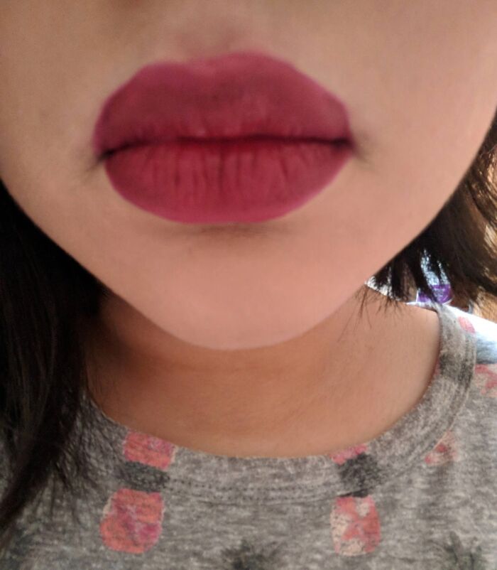 Closeup of a person's mouth with dark pink, matte lipstick. A beauty disaster that feels almost criminal.