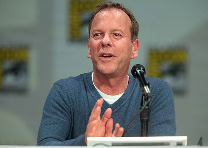 Male celebrity speaking at a panel event, illustrating beloved celebrities that are not that nice in real life.