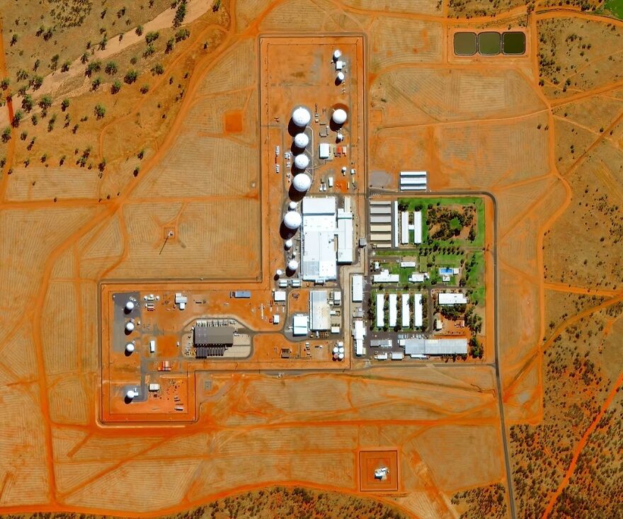 Aerial view of a highly secure facility with multiple buildings and white domes, making it an off-limits place.