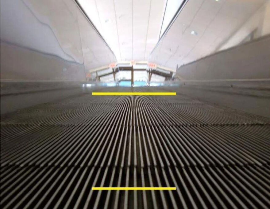 A brain-bending optical illusion: A flat, ribbed surface with yellow lines appears as an escalator going up.
