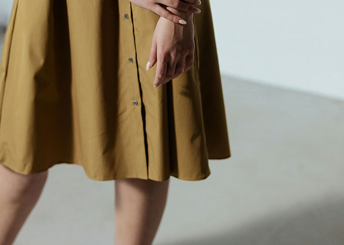 Closeup of person’s hands resting on their skirt, symbolizing concern as people believe economy is not doing well.