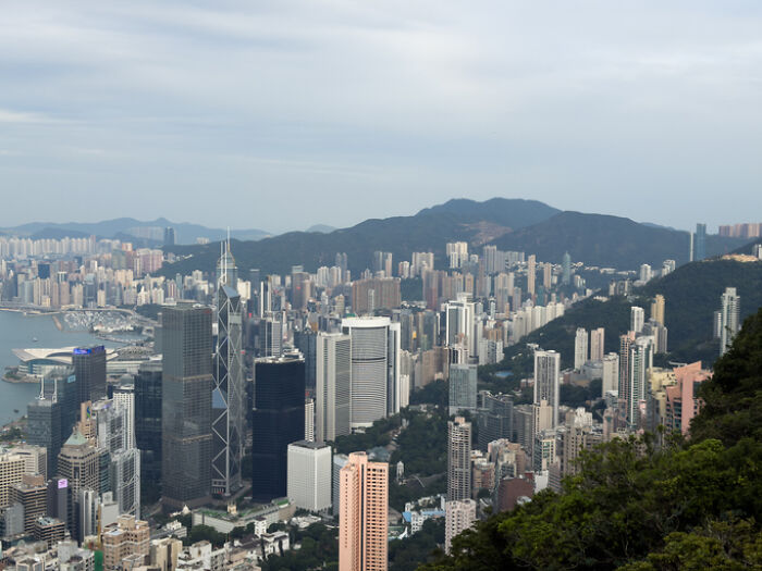 Hong Kong city skyline with skyscrapers and mountains, reflecting a region with challenging Work-Life Balance.
