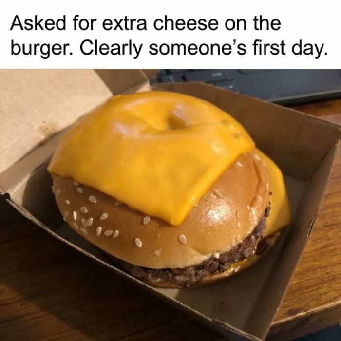Burger with melted cheese unevenly covering the top bun, illustrating a funny food meme with quick chuckles.