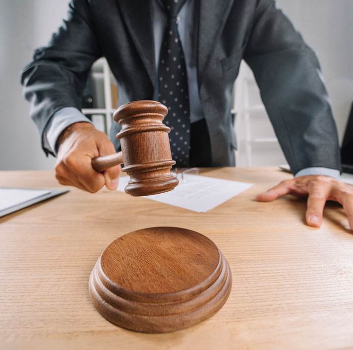 Male judge in suit striking wooden gavel on desk, representing moments when oversleeping turned into a nightmare.