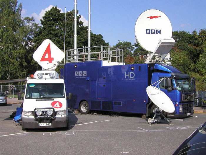 Broadcast vans with large satellite dishes parked outdoors, illustrating social media posts and campaigns.