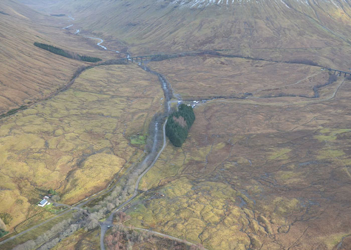 Aerial view of a remote landscape with winding roads and sparse greenery symbolizing a devastated bride-to-be uncovering horrific crimes.
