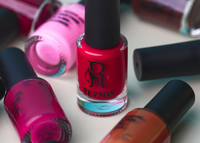 Various nail polish bottles arranged on a surface illustrating people believe signs show the economy is not doing well.