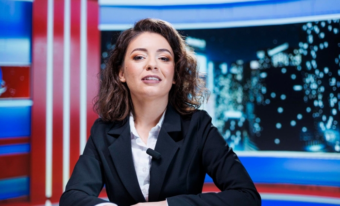 Woman in a news studio preparing to report on a cheating and scamming story involving a best friend’s exposure.