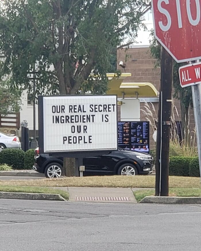 A weird image of a drive-thru sign on a car that says, Our real secret ingredient is our people.