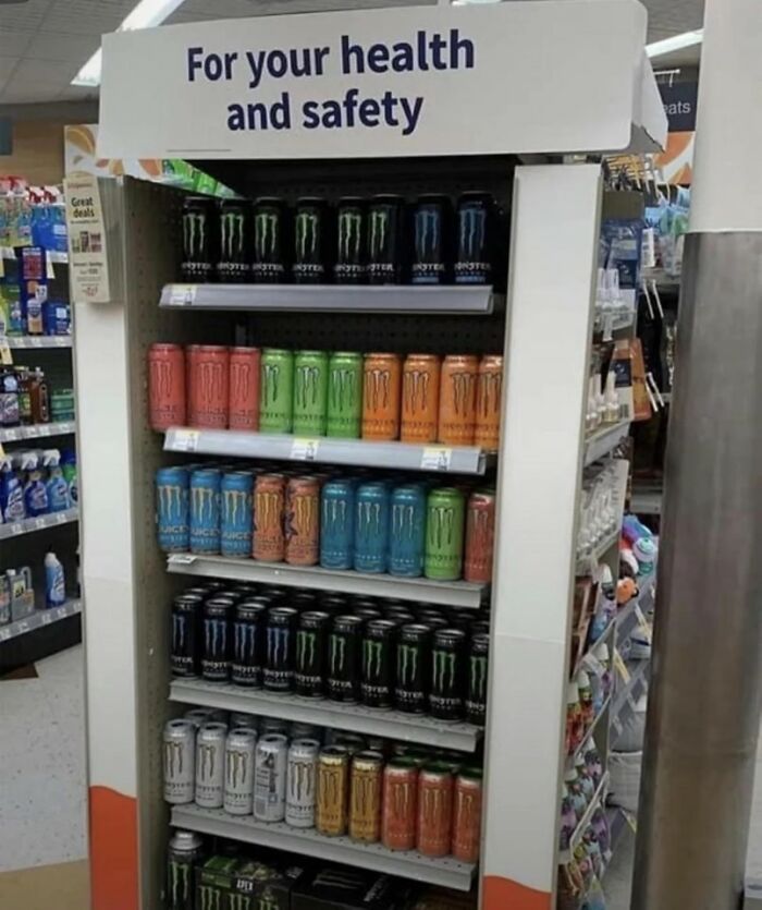 A retail display of Monster energy drinks with a sign saying "For your health and safety," a weird image.